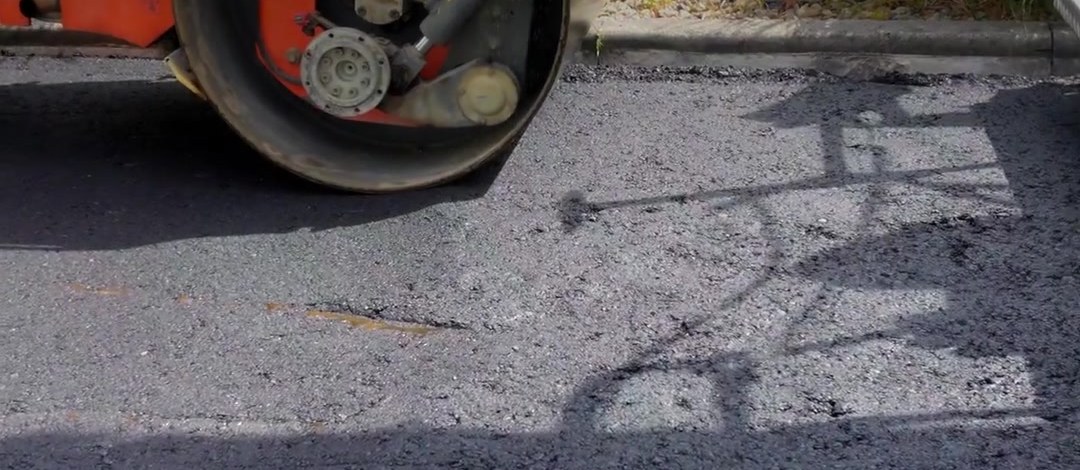 Frisch eingebauter Asphalt und Pflasterkante